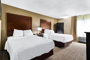 two beds in a hotel room with white sheets at Comfort Inn Evansville East in Evansville +52 photos