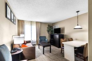 a hotel room with a living room at Comfort Inn Evansville East in Evansville