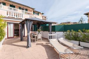 a patio with a table and chairs and an umbrella at Del Prado in Riva Ligure