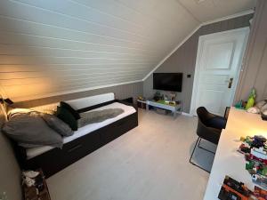 a room with a bed and a tv and a table at Big villa with outbuilding in Sarpsborg