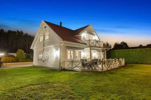 a white house with a deck on a lawn at Big villa with outbuilding in Sarpsborg