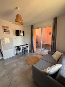 a living room with a couch and a table at Appartement T2 moderne - Résidence Lecci - Piscines & proche Mer in Lecci