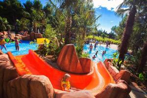 a little girl sitting on an orange slide at a water park at Apartments Dalmata in Krapanj