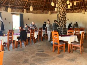 a group of people standing at tables in a restaurant at AMBOKILI COTTAGES AMBOSELi in Nairobi