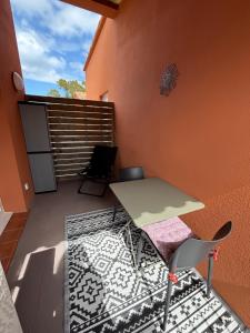 a patio with a table and chairs on a balcony at Appartement T2 moderne - Résidence Lecci - Piscines & proche Mer in Lecci +1 photo