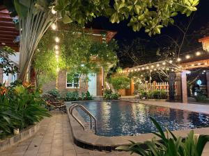 a swimming pool with lights in a yard at night at Cosiana Homestay in Ninh Binh