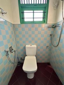 a bathroom with a white toilet and a window at Rella Dream in Matara