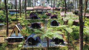 a group of tents in a forest with trees at serlok glamping in Tangkubanperahu