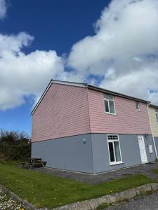 a large red and white building with a picnic table at Seashells in Newquay