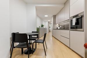 a kitchen and dining room with a table and chairs at LAM Schon - AC in Bratislava