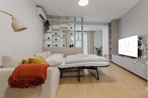 a living room with a white couch and a tv at LAM Schon - AC in Bratislava