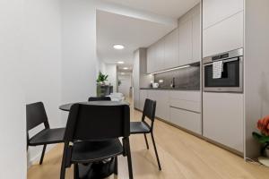 a kitchen and dining room with a table and chairs at LAM Schon - AC in Bratislava