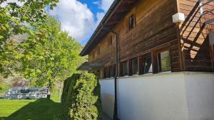 a wooden house with a gate next to a yard at Gruppenhaus Grächbiel in Grächen