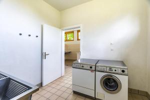 a kitchen with a washer and dryer in a room at Gruppenhaus Grächbiel in Grächen