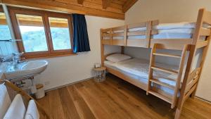 a bathroom with two bunk beds and a sink and a sink at Gruppenhaus Grächbiel in Grächen
