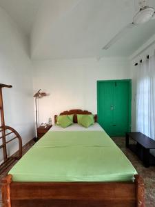 a bedroom with a green bed and a green cabinet at Rella Dream in Matara