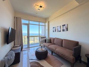 a living room with a couch and a large window at Serenity Ocean Garden Boracay in Boracay