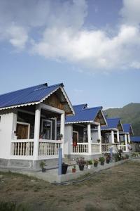 a row of houses with blue roofs at Sangti River Front Homestay in Dirang Dzong