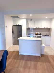 a kitchen with a white counter and a refrigerator at Stylish inner-city Haven in Braddon