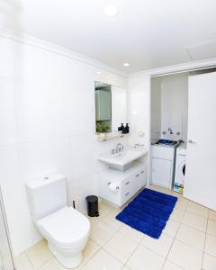 a white bathroom with a toilet and a sink at Stylish inner-city Haven in Braddon +24 photos