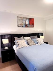 a bedroom with a large bed with a black headboard at Stylish inner-city Haven in Braddon