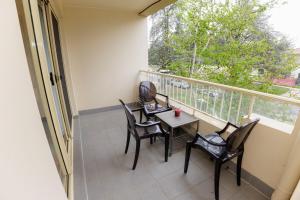 a balcony with four chairs and a table and a window at Stylish inner-city Haven in Braddon