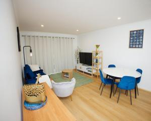 a living room with a table and blue chairs at Stylish inner-city Haven in Braddon