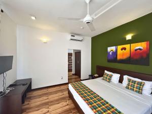 a bedroom with a bed and a green wall at The Suite 262 in Negombo +44 photos