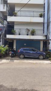 a blue car parked in front of a building at Masterkey stay in Kakkanad
