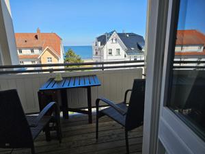 a balcony with a table and chairs and the ocean at Villa Kurfürst - 100 m zum Strand in Bansin