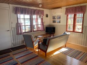a living room with two chairs and a table and a television at Vuonamo - Summer cottage in Keitele