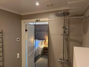 a bathroom with a shower and a bedroom at Strandlogiet Ljugarn in Ljugarn +61 photos