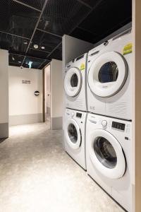 two washing machines sitting next to each other in a room at Heritage Collection on Victoria - Mobile App Check-In in Singapore