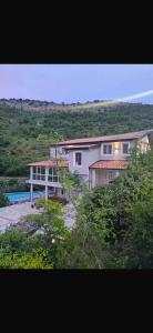 a large white house in the middle of a field at guest house Qyteza in Shkodër