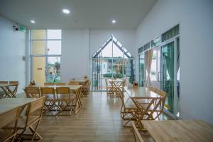 a restaurant with wooden tables and chairs and windows at Terra Sky Home in Pak Chong