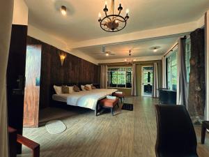 a bedroom with a bed and a chandelier at Shvaas Boutique Villa in Dambawelagama