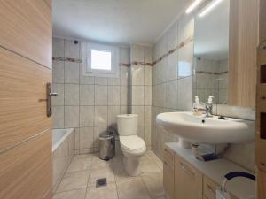 a bathroom with a toilet and a sink at Remvi Beachfront Suites by Horizon Homes in Orfánion +9 photos