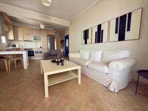 a living room with a white couch and a table at Remvi Beachfront Suites by Horizon Homes in Orfánion
