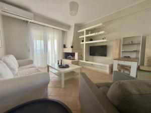 a living room with a couch and a table at Remvi Beachfront Suites by Horizon Homes in Orfánion