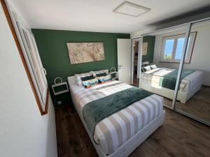 a bedroom with two beds and green walls at Chalet panoramique avec vue alpine à 180 degrés - poêle scandinave & nature in Grône