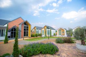 a row of houses in a yard with flowers at Terra Sky Home in Pak Chong