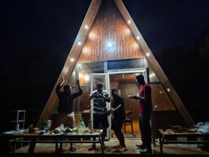 a group of people standing outside of a tiny house at The Brookshore in Kodaikānāl +11 photos