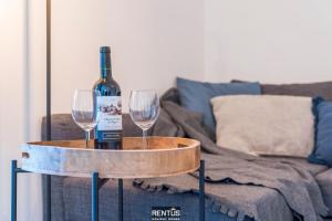 a bottle of wine on a table with two wine glasses at Sandy View - spacious studio flat near the beach in Nieuwpoort