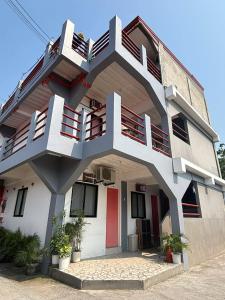 a white building with a red door and balcony at Maru Vibe Studio unit in San Juan