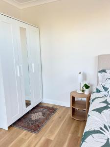 a bedroom with a bed and a dresser with a mirror at La Porta Rosa in Bunbury