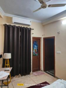 a living room with a black curtain and a door at Uma's Homestay in Gwalior