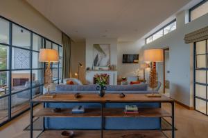 a living room with a blue couch and a table at Rubi Ranch Lakehouses in Naivasha