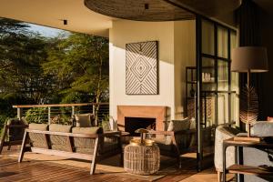 a porch with a couch and a fireplace at Rubi Ranch Lakehouses in Naivasha