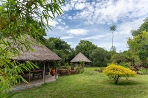 a garden with a hut with a table and chairs at Oreteti Mara Lodge in Lolgorien