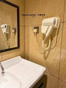 a bathroom with a phone on a wall next to a sink at Tokiyo Suites Hotel Kinta River Ipoh Town in Ipoh